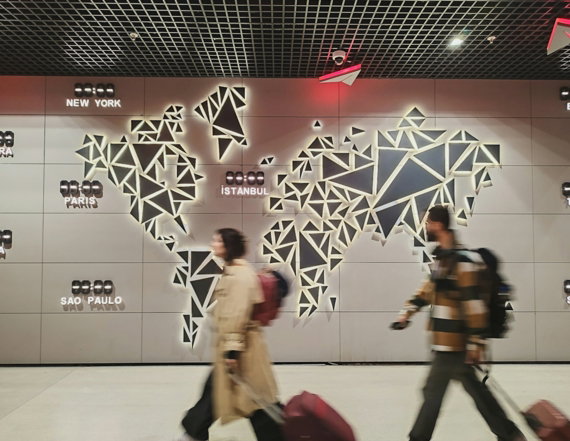 People walk past a glowing world map.